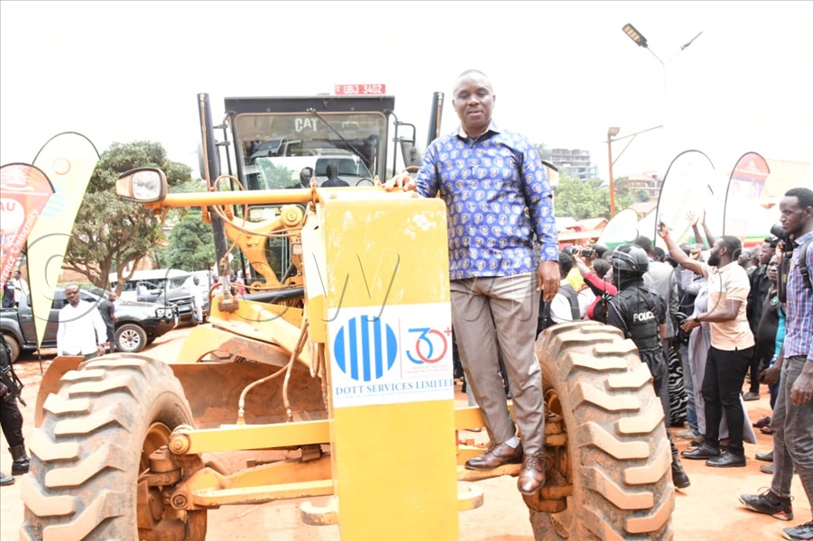 Lord mayor Erias Lukwago on top of a DOTT Services grader