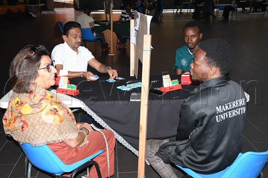 Jyotsna Ruparelia (left) chats with students after playing a demonstration game before the start of the Ruparelia Foundation National Bridge League at Kampala Parents School. Photo by Michael Nsubuga