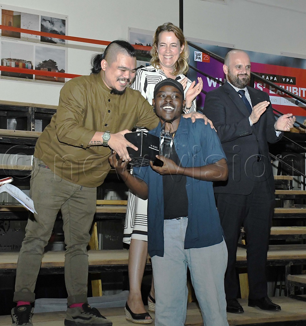 Joel Gabriel Agaba receiving a Fuji film camera from Jandri Angelo Aguilor, a marketing specialist of Fujifilm in Middle East and Africa after Agaba claimed the Young Photographer Award at the UPPA 2025 Photo Exhibition. (Photo by Ignatius Kamya)