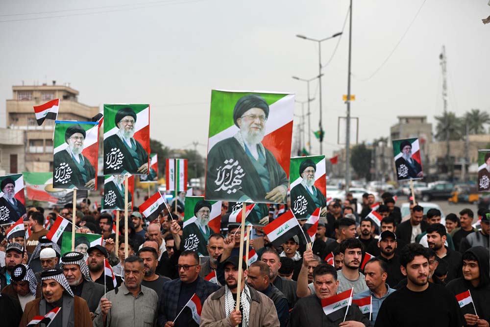 Waving the Iraqi flag and holding up placards with the image of the assassinated Iranian supreme leader Ayatollah Ali Khamenei, Iraqis rally in support of neighbouring Iran, in the al-Aamil district of Baghdad on March 22, 2026. On February 28, Israel and the United States launched strikes on Iran killing its supreme leader and triggering a war that spread across the Middle East and unleashed chaos across global markets and sent oil prices soaring. (Credit: AFP)