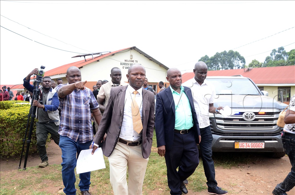 Simon Nabaasa (second from L), the Buheesi Secondary School managing committee chairperson and Annaline Turyahebwa (third from L), the school headteachers being escorted by the officers of the Anti-Corruption Unity to answer to allegations of extorting students through excessive fees.