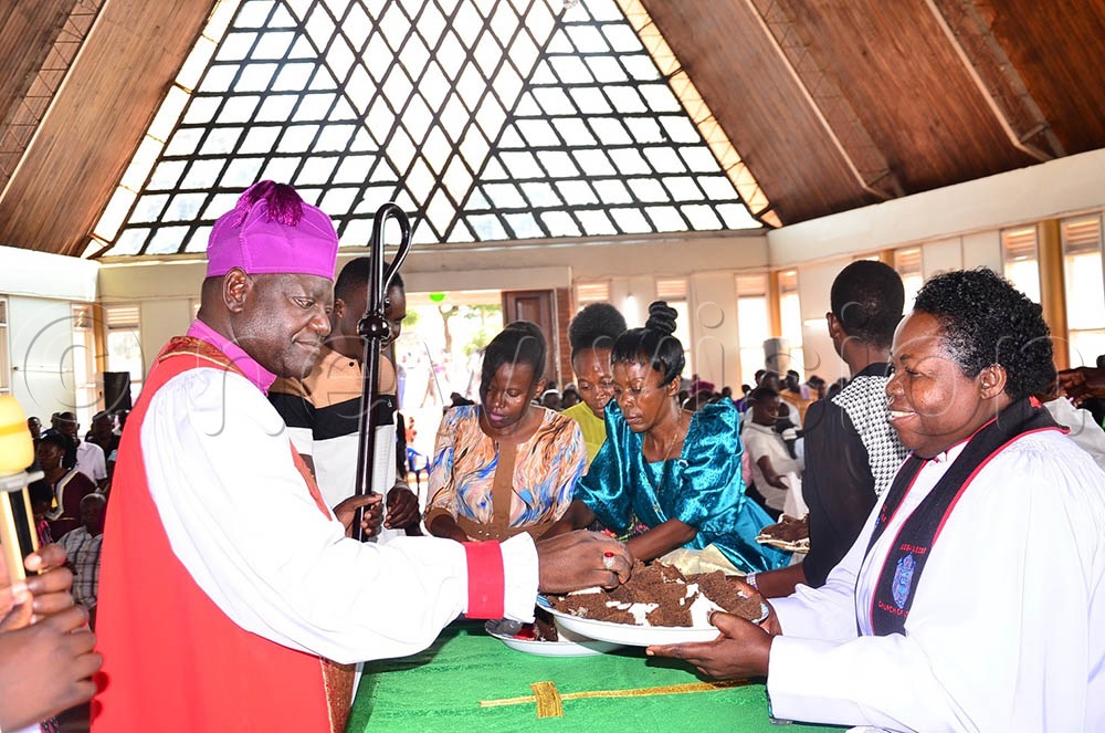 Naimanhye being served a cake by the Dean, the Very Rev. Can. Dr. Joy Mukisa Isabirye, during the farewell service at the cathedral on July 20, 2025. (Credit: Jackie Nambogga)
