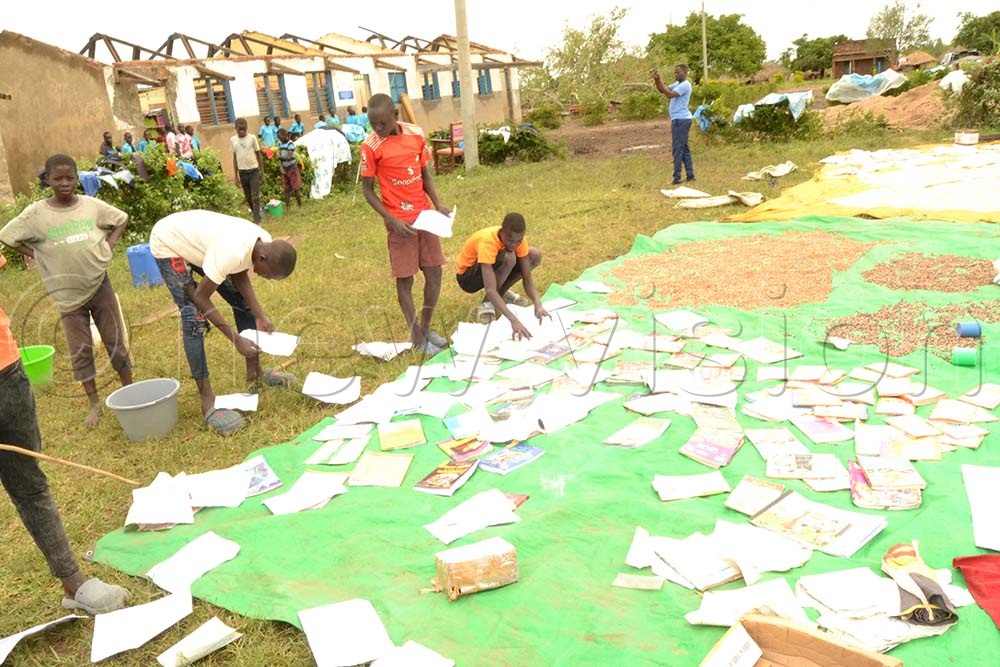 Pupils sun-dry their books, which were destroyed by rain. (Credit: Jasper Egwel)