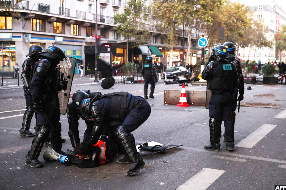 Police officers detain a protestor near the Olympia venue during the demonstration in Paris on October 17, 2026