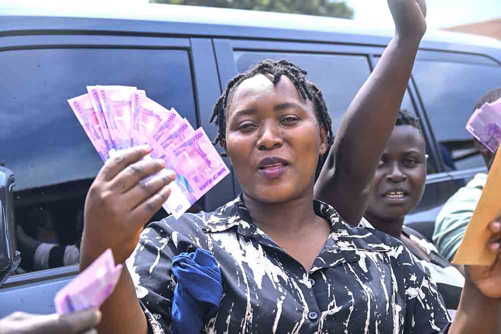 Jackie Kyomuhendo, a fruit and vegetable vendor showing off the cash while making her remarks after receiving President Yoweri Kaguta Museveni’s financial support to boost their business at Bombo Central Market in Bombo Wakiso District on September 22, 2025. Credit: PPU/Tony Rujuta)