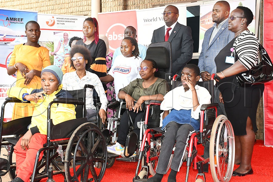 Absa Bank's CFO Michael Segwaya (3rd right) and the Hash Master Wilson Asiimwe (2nd right) pose with beneficiaries from Katalemwa Chesire Home at Absa head offices, June 18, 2025. Photo by Michael Nsubuga