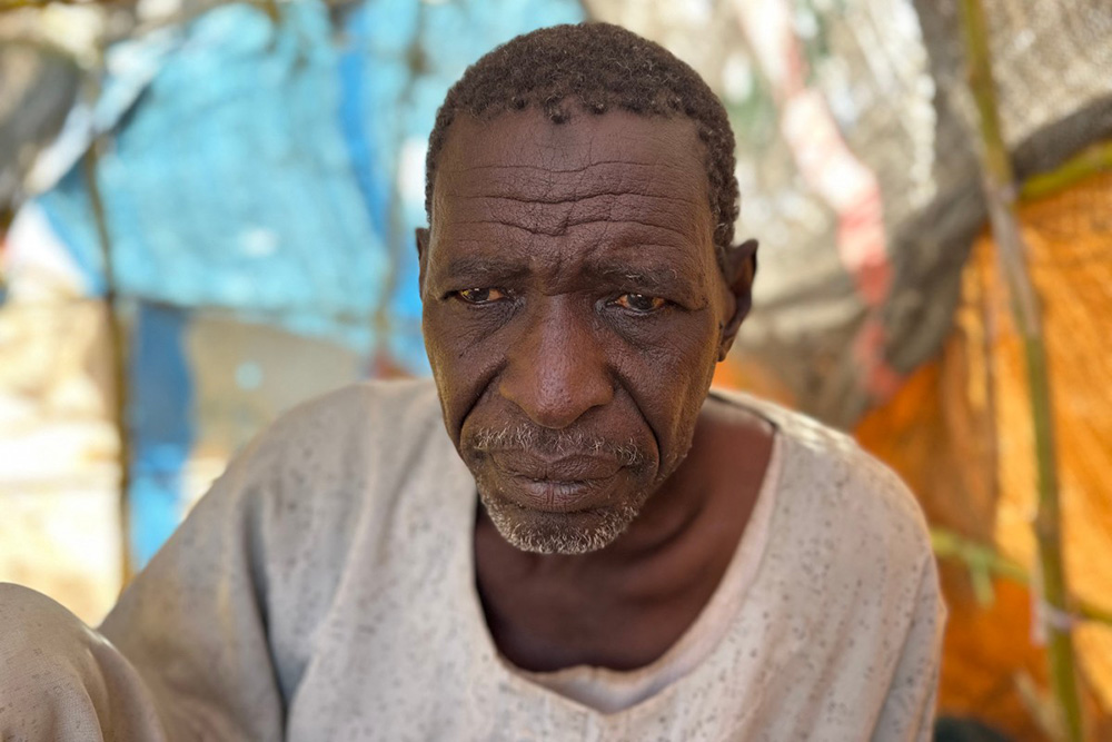 Sudanese displaced Ahmed Aman, who says he was imprisoned and tortured in Rapid Support Forces' (RSF) prisons before fleeing El-Fasher, sits at a makeshift shelter in the town of Tawila, in war-torn Sudan's western Darfur region on March 2, 2026. (Photo by AFP)