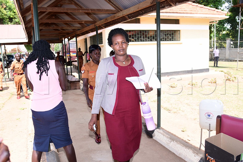 Suspect Suzan Vivan Ariokot, wife of Joseph Okedi, being escorted into court. (Photo by Godfrey Ojore)
