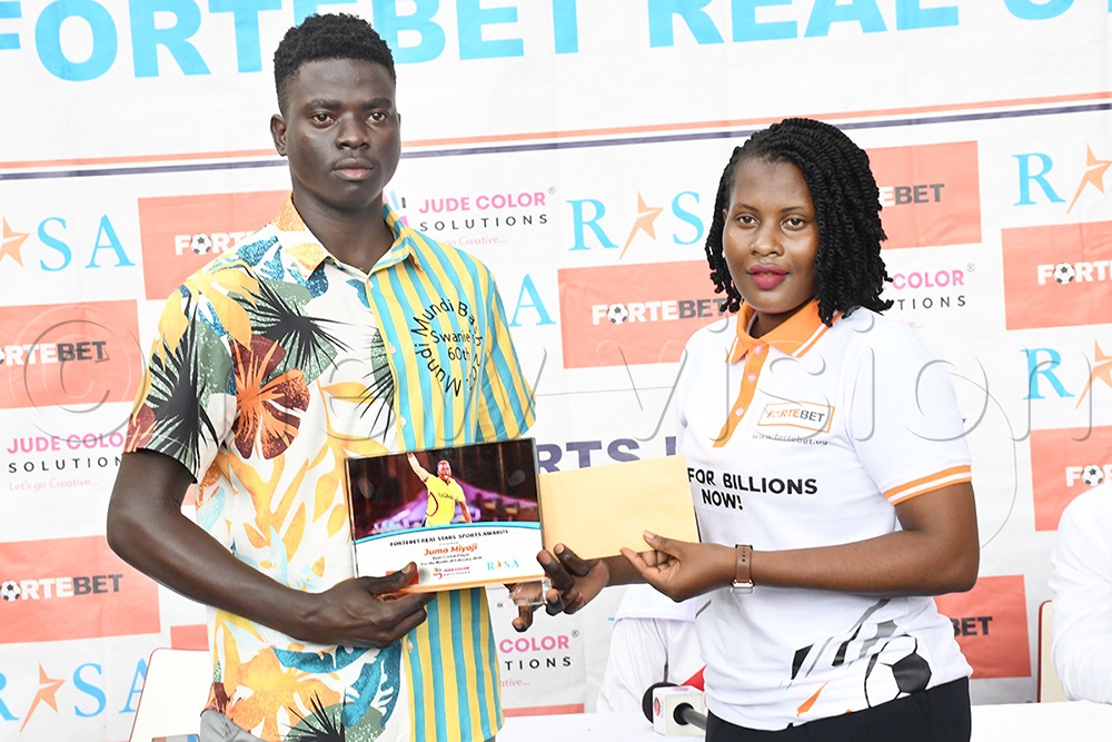 Real Stars Awardee Juma Miyagi (left), receives his award from Fortebet's Resty Mbatidde at Lazio restaurant, March 4, 2025. (Credit: Michael Nsubuga)