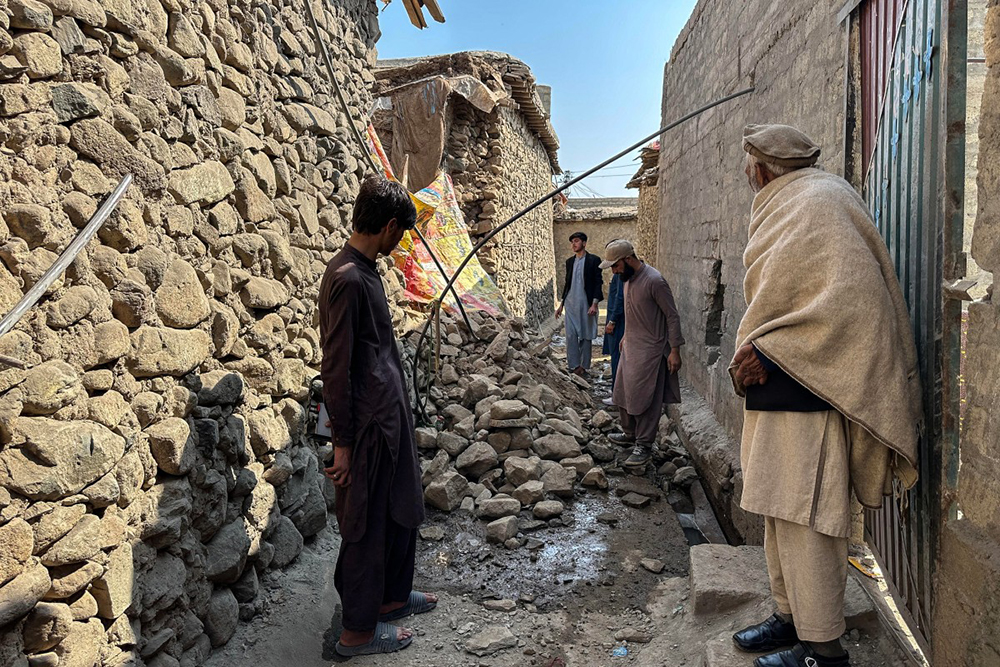 Residents stand near a damaged house following the overnight cross-border fighting between Pakistan and Afghanistan in Bajaur, Khyber Pakhtunkhwa province, on February 27, 2026. Pakistan bombed major cities in Afghanistan including the capital Kabul on February 27, with Islamabad's defence minister declaring the neighbours at "open war" following months of tit-for-tat clashes. (AFP Photo)