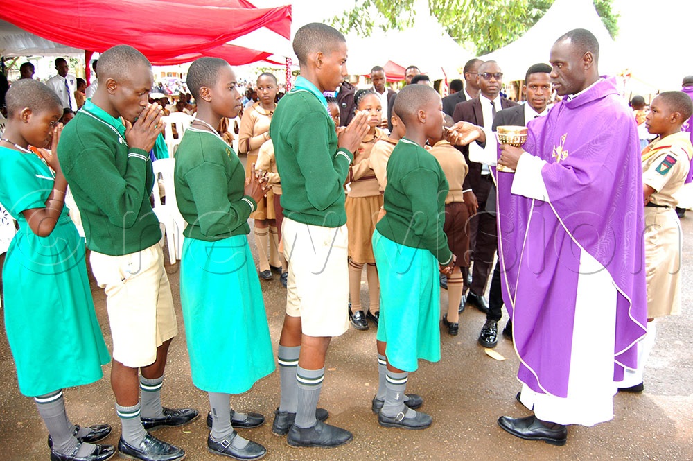 Fr. John Mary Kibirige distributing Holy Communion during mass. (Photo by Mathias Mazinga)