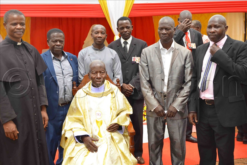 Fr Kabuye shares a photo-moment with Christians during his priestly diamond jubilee celebration in 2022.