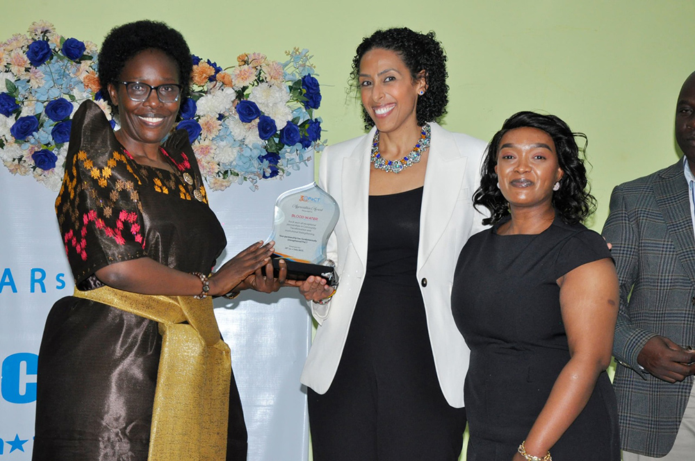 Lands minister Judith Nabakooba receving an award during the commemoration of 30 years of Partners for Community Transformation (PaCT). (Courtesy photo)