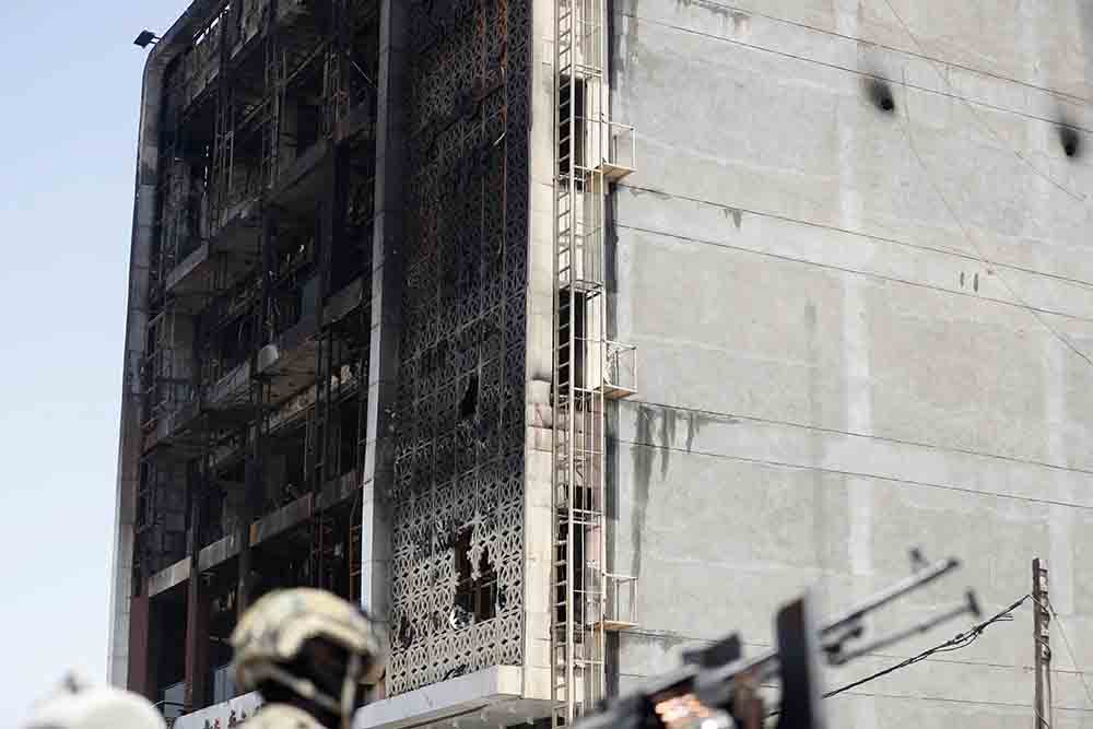 A member of the Iraqi security forces mans a position on July 17, 2025 in front of the damaged shopping mall after a fire tore through the newly opened Hyper Mall overnight in the eastern Iraqi city of Kut, killing at least 60 people, according to Iraqi authorities. Officials have launched an investigation into the blaze, the latest in a country where safety regulations are frequently neglected. (Credit: AFP)