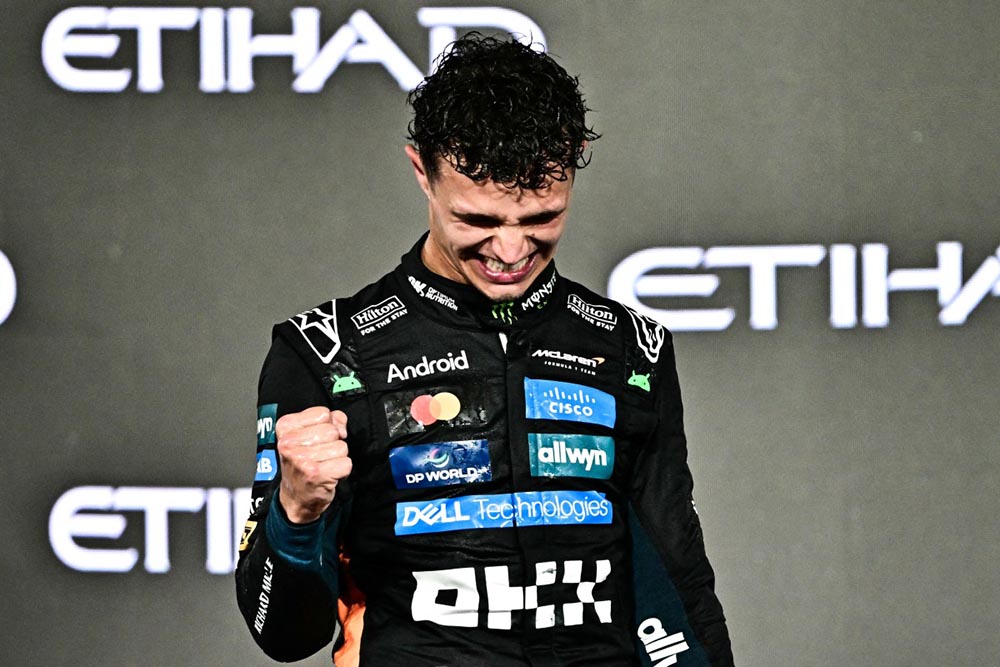 World champion and race third-placed McLaren's British driver Lando Norris celebrates on the podium at the end of the Abu Dhabi Formula One Grand Prix at the Yas Marina Circuit in Abu Dhabi on December 7, 2025. (Credit: AFP)