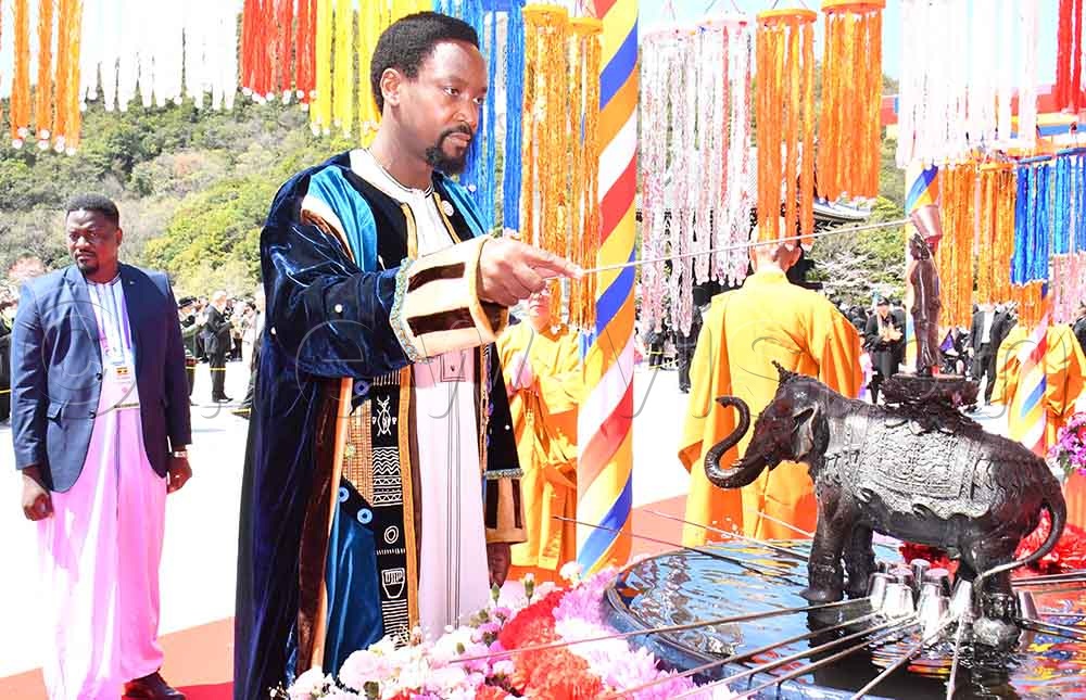King of Busoga William Gabula Nadiope IV (C) performing Kanbutsu, the ritual of pouring the sacred water onto the statue of newborn Buddha at the flowered shrine outside the Royal Grand Hall of Buddhism in Nenbutsushu Sampozan Muryojuji Head Temple in Kobe City, Japan. (Credit: Donald Kiirya)
