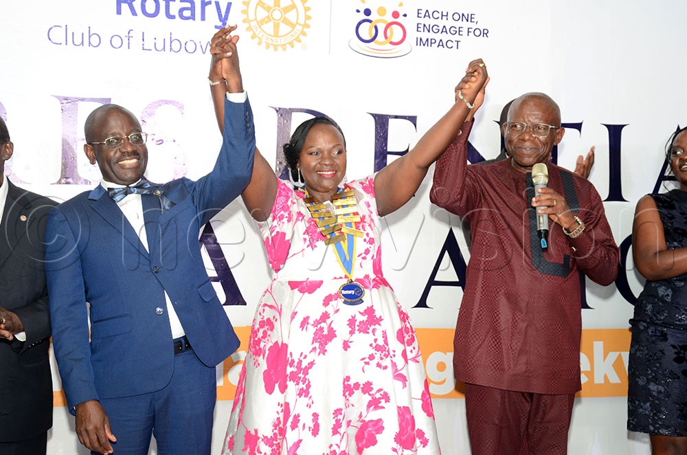 Past Assistant District Governor Godfrey Byekwaso (L) and Past District Governor District 9213 Francis Xavier Sentamu (R) showing Clare Nakabonge Byekwaso to the guests after she was installed as the new president for the Rotary Club of Lubowa. This was during her installation at Orion gardens Lweza on May 16, 2026. (Credit: Lawrence Mulondo)