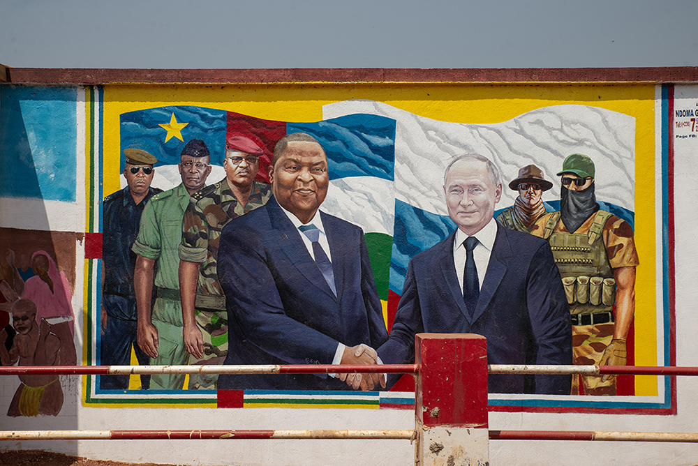 A general view of a large mural depicting Central African Republic's President Faustin-Archange Touadera  (CL) and Russia's President Vladimir Putin (3rd R) shaking hands, on the wall of the Combattant Market in Bangui on December 22, 2025.  (Photo by Annela NIAMOLO / AFP)