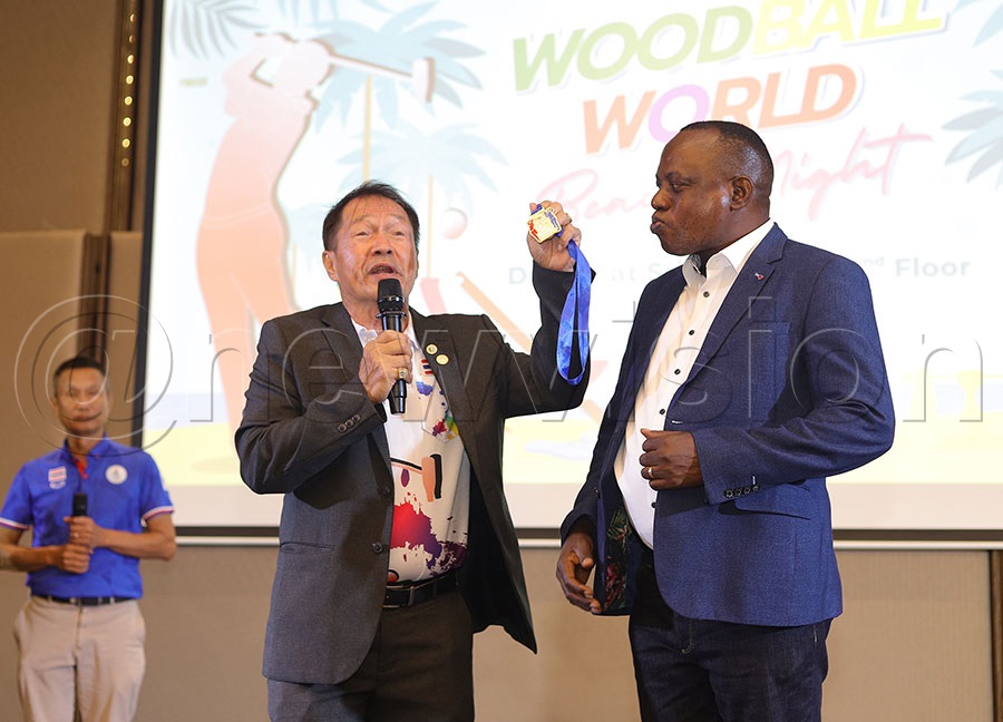 Uganda Woodball Federation president Paul Mark Kayongo (R) recieves an award amedal for his contributions to the sport from Dr. Patanacharrt Kridibwon of Thailand Woodball