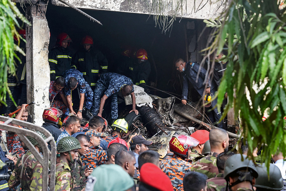 Bangladesh's fire service and security personnel conduct a search and rescue operation after a Air Force training jet crashed into school in Dhaka on July 21, 2025. (AFP)