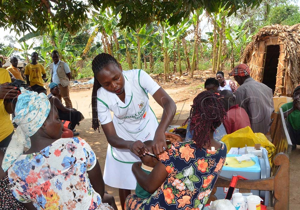  A nurse vaccinating a mother during the integrated outreaches at Mabo Island.(Credit: Violet Nabatanzi)