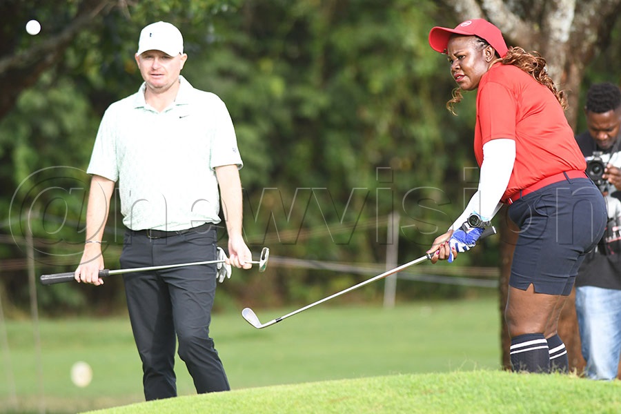 Hellen Lunkuse chips as pro James Morrison looks on during the Magical Kenya Open Pro-Am at Karen Golf Club. Photo by Michael Nsubuga