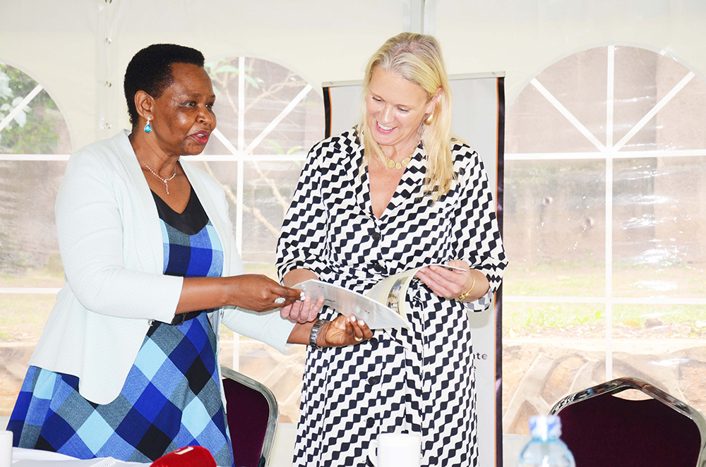 State House Investors Protection Unit head, Col Edith Nakalema, handing over a report book to the British High Commissioner, Lisa Chesney at Lumumba Avenue offices. (Photo by Isaac Nuwagaba)