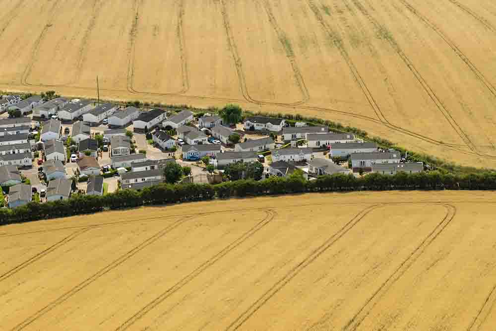 This aerial photo shows homes surrounded by dry fields in the village of Reculver, on the coast of eastern England on August 6, 2026. England and Wales both experienced the "driest July on record", the UK Met Office weather agency said on August 3, based on provisional figures. (Credit: AFP)