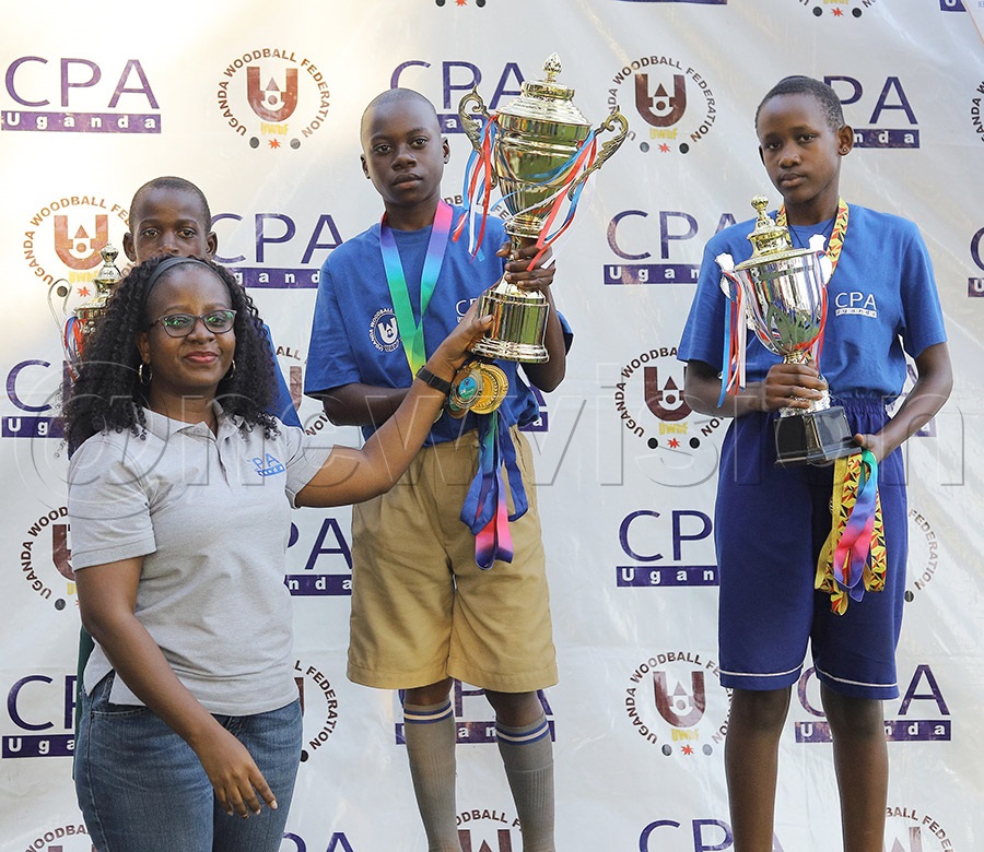 ICPAU's Lydia Tusiime hands over the trophy to the winner, Busukuma Church of Uganda Primary School team captain, during the awards ceremony. &mdash; Photo by Johnson Were