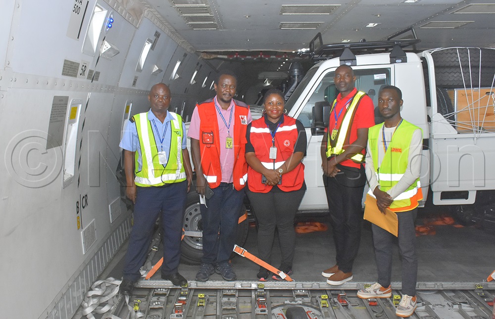 Nathan Kimani (second left), the IFRC Regional Fleet Representative for Africa, and Irene Nakasiita (centre), Director of Communications, Resource Mobilisation and Partnerships at the Uganda Red Cross Society, with other staff inside the cargo plane transporting 18 vehicles destined for the Democratic Republic of the Congo to support the Ebola response. (Credit: Julius Luwemba)