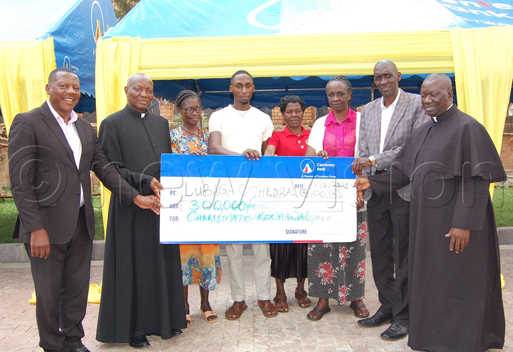 Members of Lubaga Cathedral Charismatic Renewal Group handing over their dummy cheque to Engineer Pius Mugalaasi (left), Fr. Pius Male (second-left) and Fr. Achilles Mayanja (right). (Photo by Mathias Mazinga)