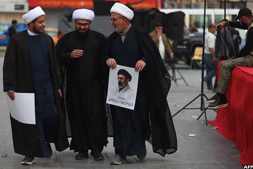 An Iraqi Shiite cleric holds a portrait of Iran's supreme leader Mojtaba Khamenei during a rally in support of Iran in Baghdad's Tahrir Square on April 2, 2026.