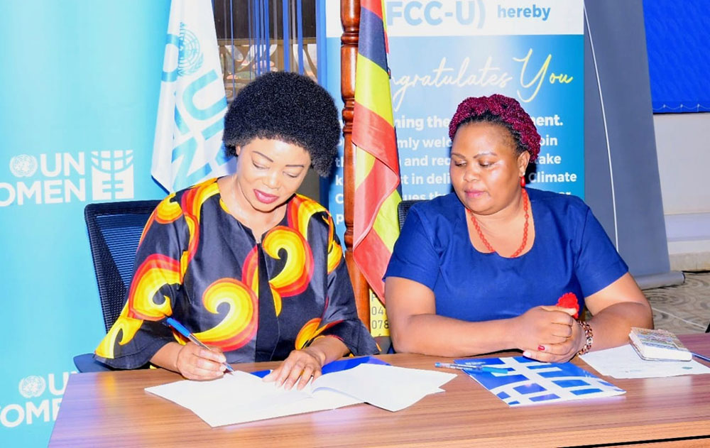 UN Women Country Representative signs the deal as Christine Nakimwero looks on.