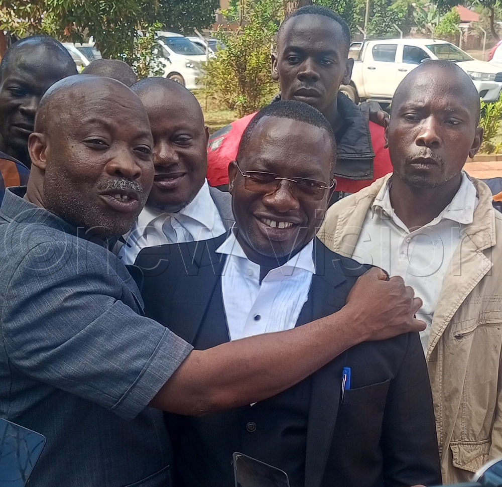 Kagoma County MP Moses Walyomu Muwanika (left) is congratulated by his lawyer, Ambrose Tebyasa. (Credit: Tonny Nsoona)