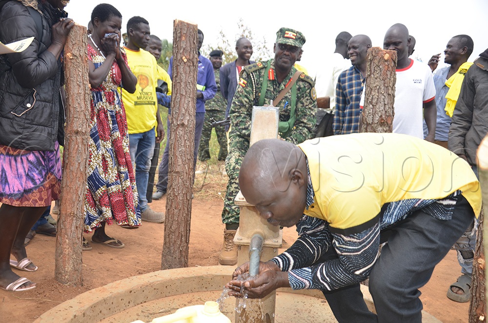 Col. Nathan Bainomugisha (Pumping water) as Michael Lakony, Amuru district chair, drinks water from a borehole during the handing over of the repaired boreholes to the community in Amuru. (Credit: Jackson Kitara)
