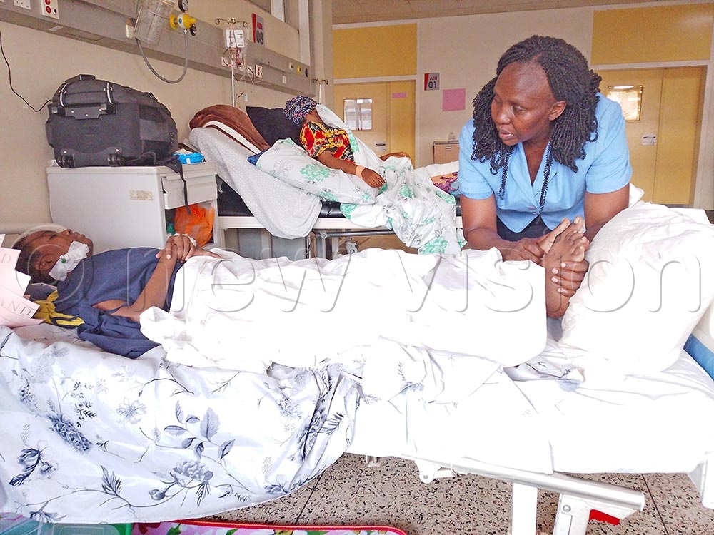 Wamakote comforts Mukhwana, in the joint repair ward at Mulago Hospital in Kampala recently. (Credit: Umar Kashaka)