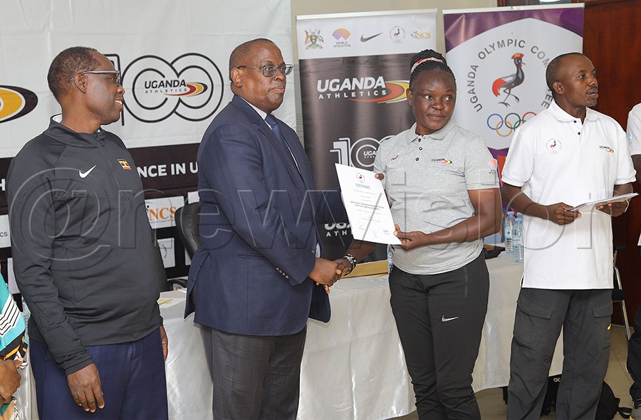Former athlete Justine Bayiga (second right) receives her certificate from Uganda Olympic Committee president Dr. Dnald Rukare as Uganda Athletics President Dominic Otucet looks on at Namboole. PHOTO: Johnson Were