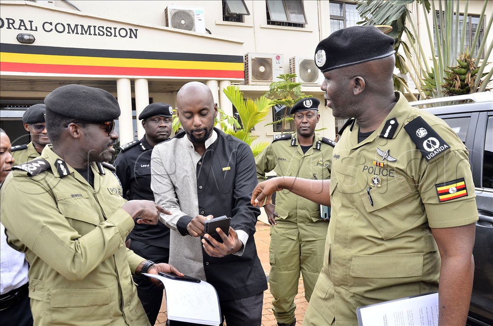 The deputy to the Director of Operations Services in Uganda Police Force (UPF), James Ruhwezi (left) and the director for operation in UPF, Frank Mwesigwa (right) listen to the secretary General of National Unity Platform (NUP), David Lewis Rubongoya after meeting between political party agents, Police and the commissioners of Electoral Commission (EC) at EC offices Kampala.