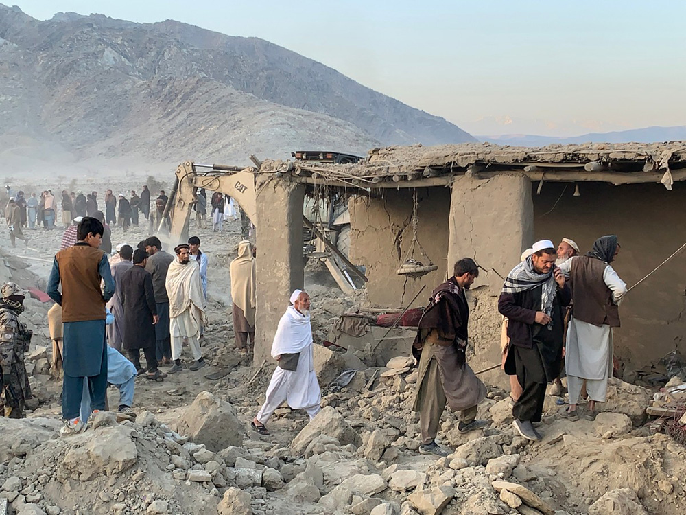 Afghan men search for victims after an overnight Pakistani air strike hit a residential area in the Girdi Kas village of Bihsud district, Nangarhar province on February 22, 2026. (Photo by Aimal Zahir / AFP)
