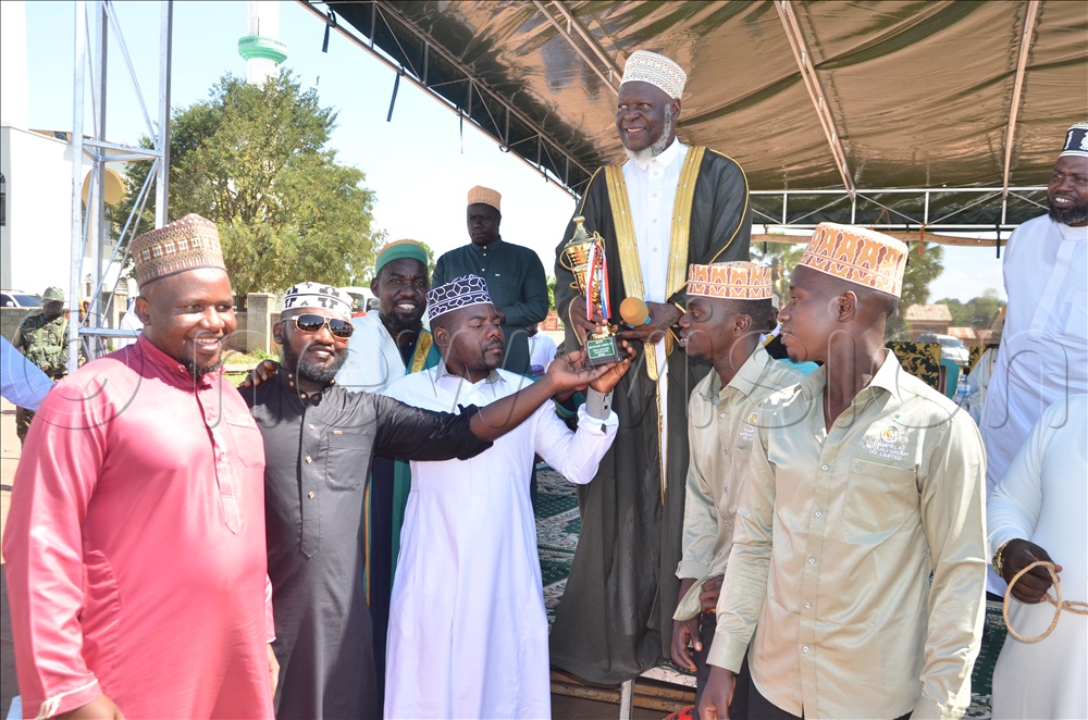 Mufti Mubaje presenting a trophy to the Mataali team from Kampala after winning the competition