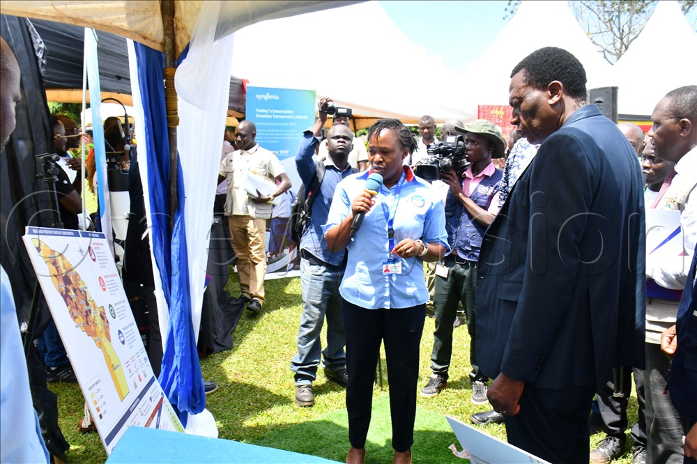 Marie Gorreti Zalwango (middle), a Malaria Specialist with the Makerere University Joint AIDS Program explaining malaria statistics in Busoga to the Director General of Health Services in the Ministry of Health Dr. Charles Olaro (right) during the inspection of stalls while at celebrations to mark World Malaria Day.  