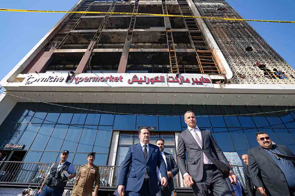A handout picture released by Iraq's Prime Minister's Media Office shows Prime Minister Mohammed Shia al-Sudani (C-L) leaves following a visit to the Corniche Hypermarket Mall in the city of Kut on July 17, 2025, after a fire tore through the newly opened mall killing at least 61 people. (Credit: AFP)