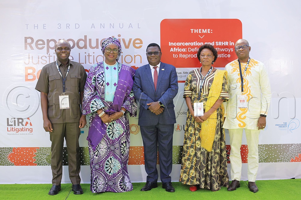 The Minister of Justice and Constitutional Affairs, Nobert Mao and the Director General of Afya Na Haki Moses Mulumba pose for a photo with other delegates. (Photo by Agnes Kyotalengerire)