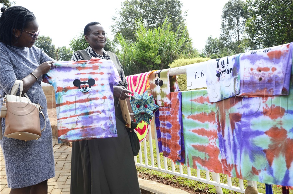 Penlope Nankunda (left), Content Manager of Digital at Vision Group looking at some of the fabrics made by children as Cathy Mayambala, Head of department of art and technology looks on during the art and technology exhibition at Gayaza Junior Jjungo Campus in Nakawuka in Wakiso district on November 08, 2025.
