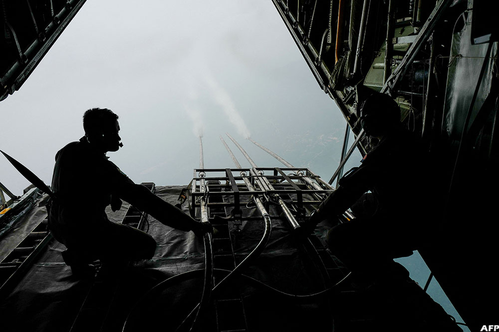 Royal Malaysian Air Force personnel start the cloud seeding process during a flight from the military base in Subang to the state of Kedah on September 19, 2019
