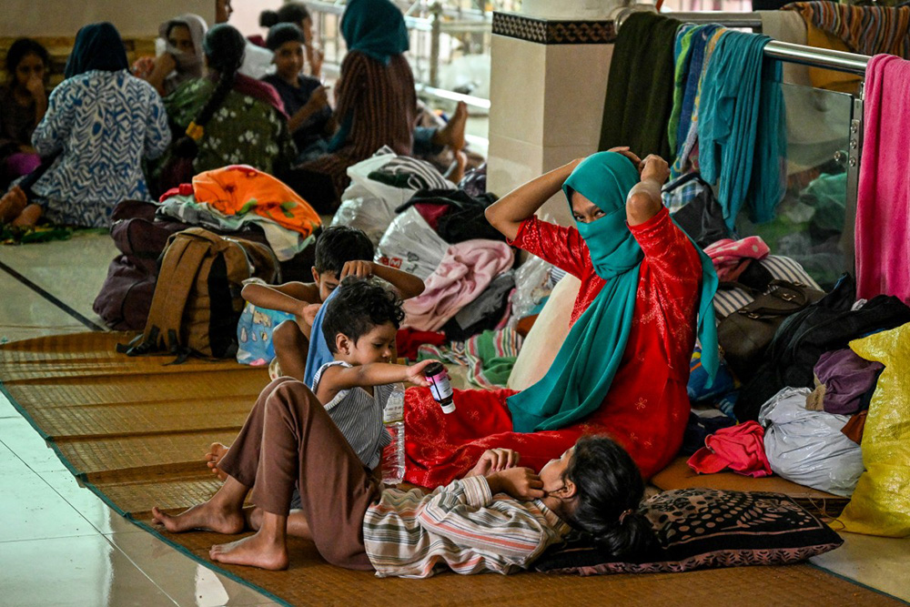 Residents take refuge at a relief camp inside a mosque after being evacuated following rapid floods in the aftermath of Cyclone Ditwah in Gampola town, in Kandy district on December 4, 2025. (Photo by Ishara S. KODIKARA / AFP)