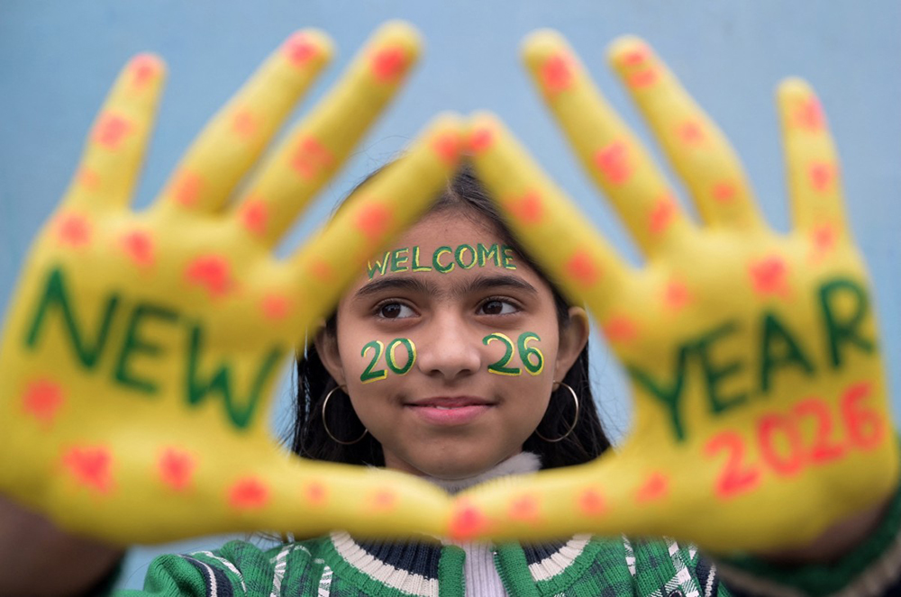 A girl poses with her painted face and hands during New Year's Eve celebrations in Amritsar on December 31, 2025. (AFP)