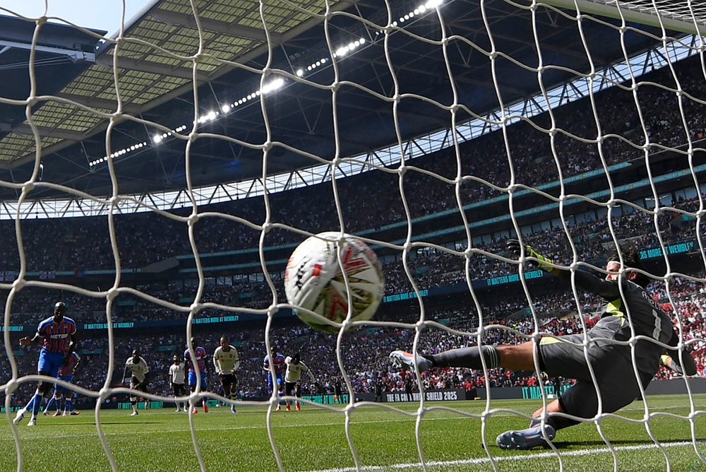 Crystal Palace's French striker #14 Jean-Philippe Mateta (L) scores their first goal from the penalty spot past Liverpool's Brazilian goalkeeper #01 Alisson Becker (R) during the English FA Community Shield football match between Crystal Palace and Liverpool at Wembley Stadium, in London on August 10, 2025. 