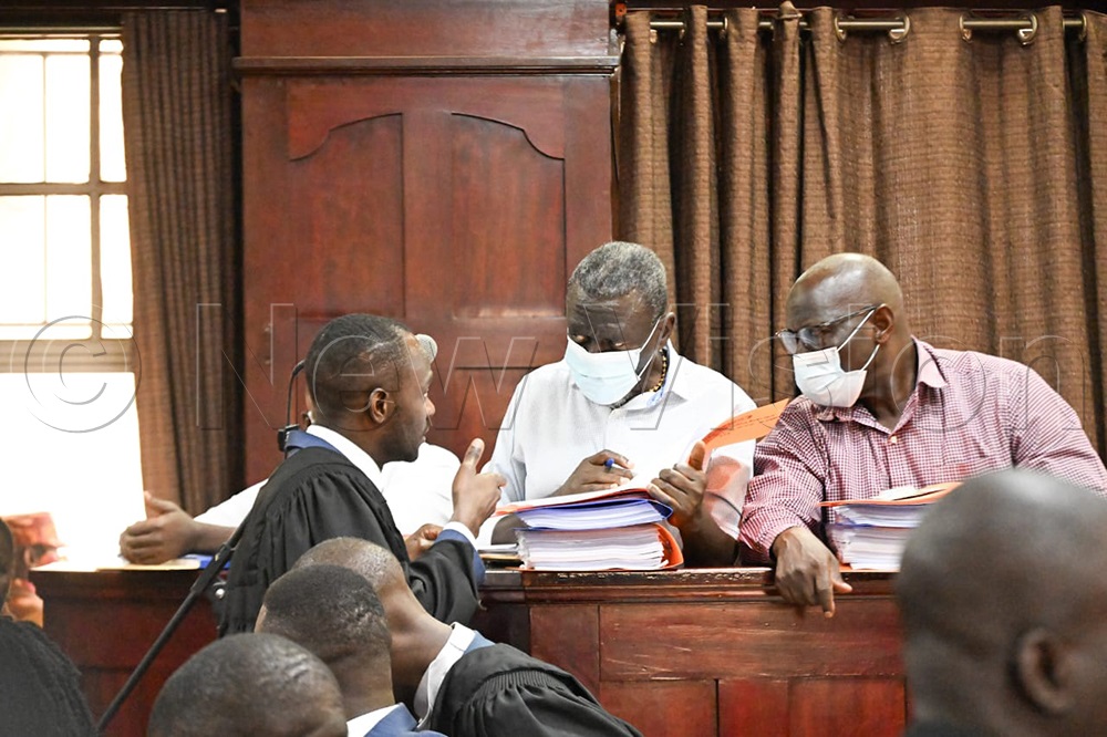 Assistant DPP Thomas interacts with Dr Kizza Besigye and his aide, Obeid Lutale, in court in the case. (Credit: Maria Wamala)