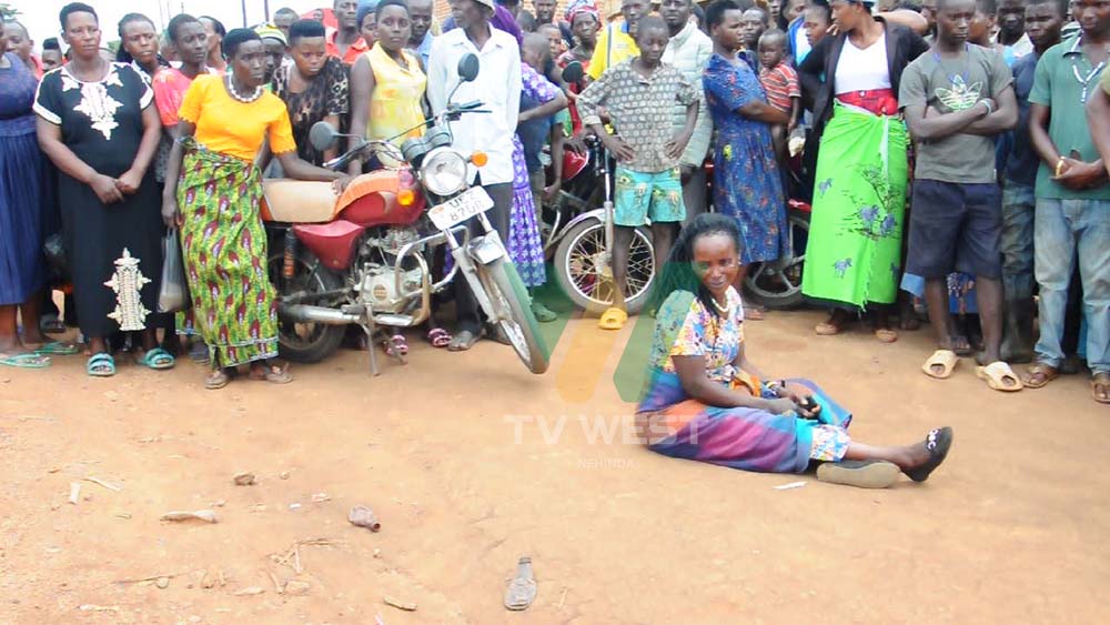 Lydia Ssengiyuva orikuteekateekwaho kuba aitsire iba yaheza kukwatwa aba abatuura Pooriisi etakizire. Photo by Andrew Musinguzi. After Her Arrest By Kagadi Police Before Angry Ruteete Residents.photo By Andrew Musinguzi
